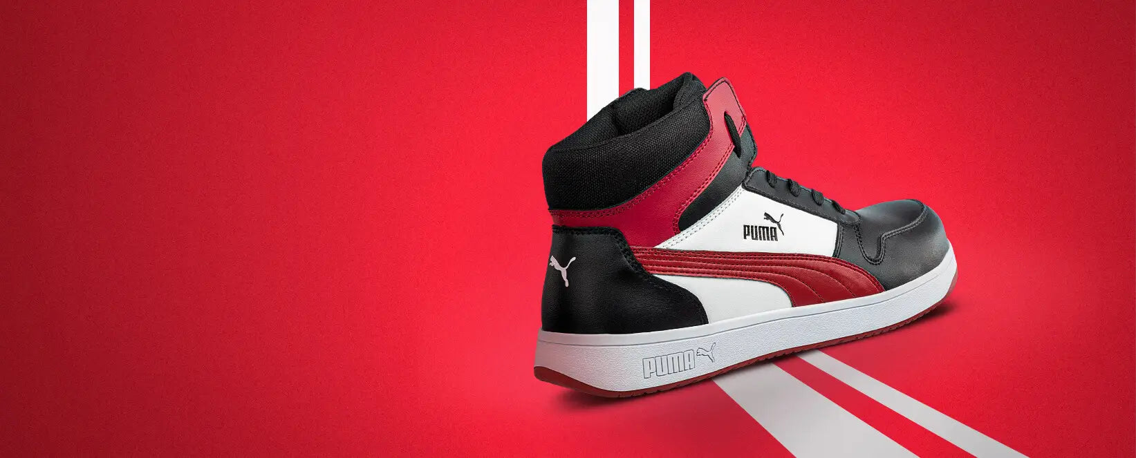 Sicherheitsschuh "Frontcourt" von Puma Safety in Schwarz, Weiß und Rot - sportlicher High-Top-Arbeitsschuh mit Puma-Design auf dynamischem roten Hintergrund.