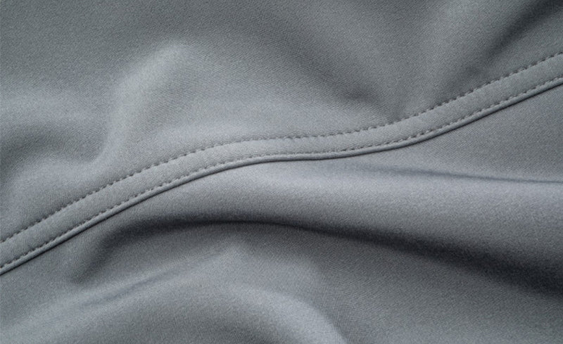 Detailaufnahme einer grauen Softshelljacke mit sichtbarer Doppelnaht.