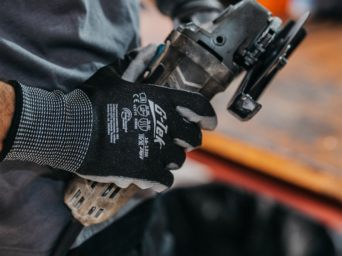 Montagearbeiter mit G-Tek Arbeitshandschuhen bei der Maschinenbedienung.